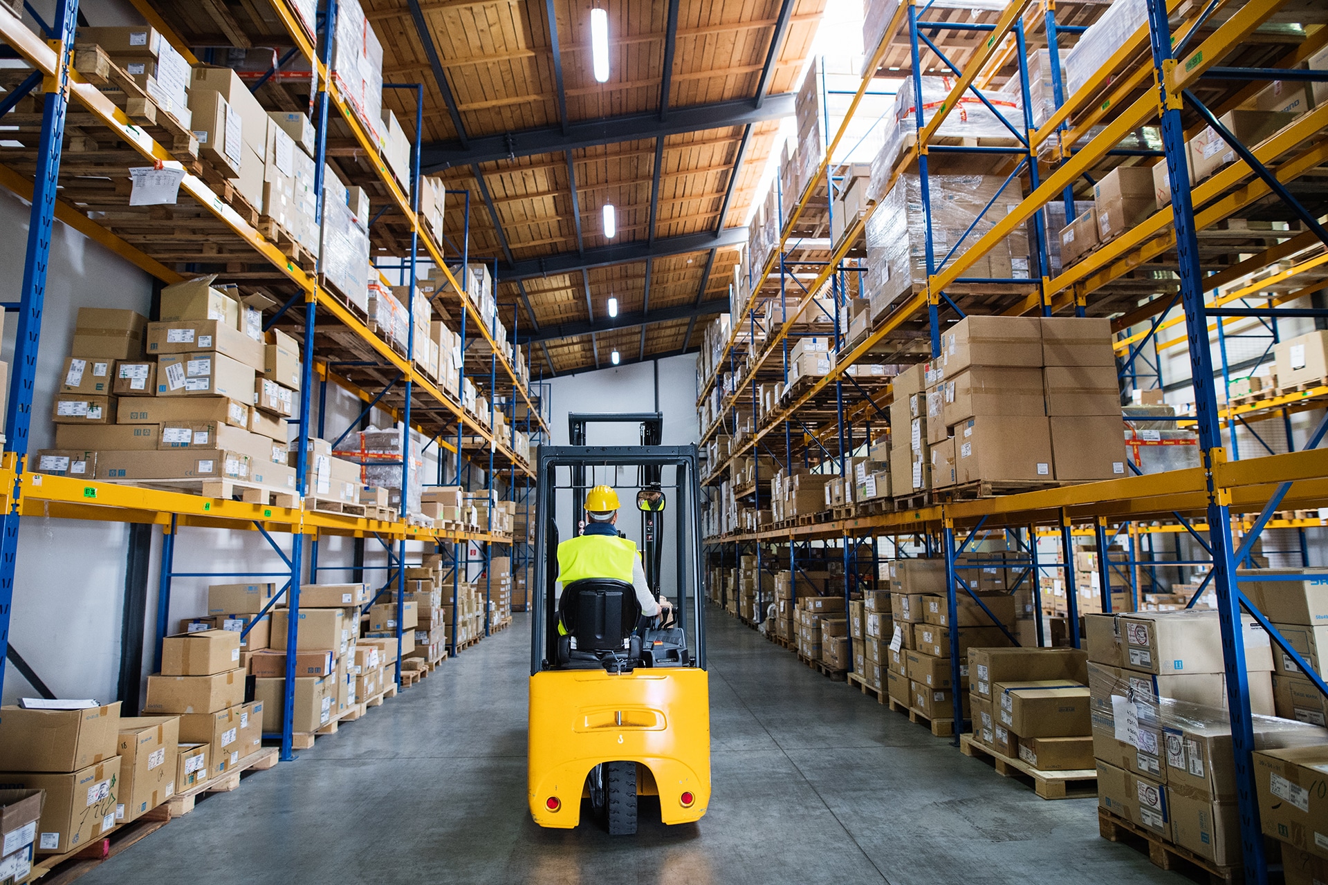 Man forklift driver working in a 3PL warehousing partner facility. Rear view. Document Storage